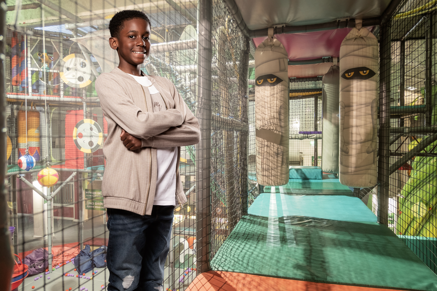 Boy smiling while playing on soft play climbing frame at Kidspace Romford indoor play centre